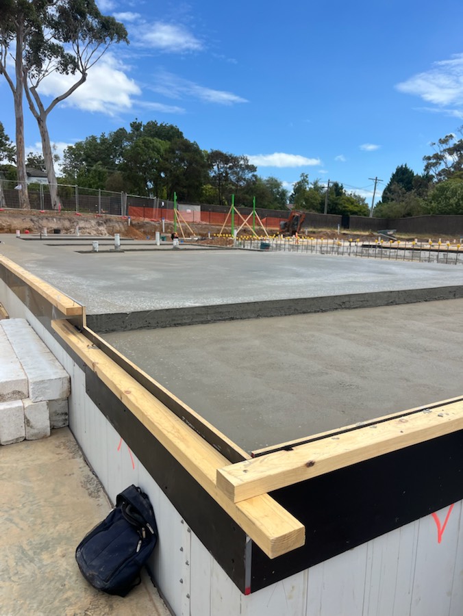 A large slab with stepped levels and edge formwork under a blue sky